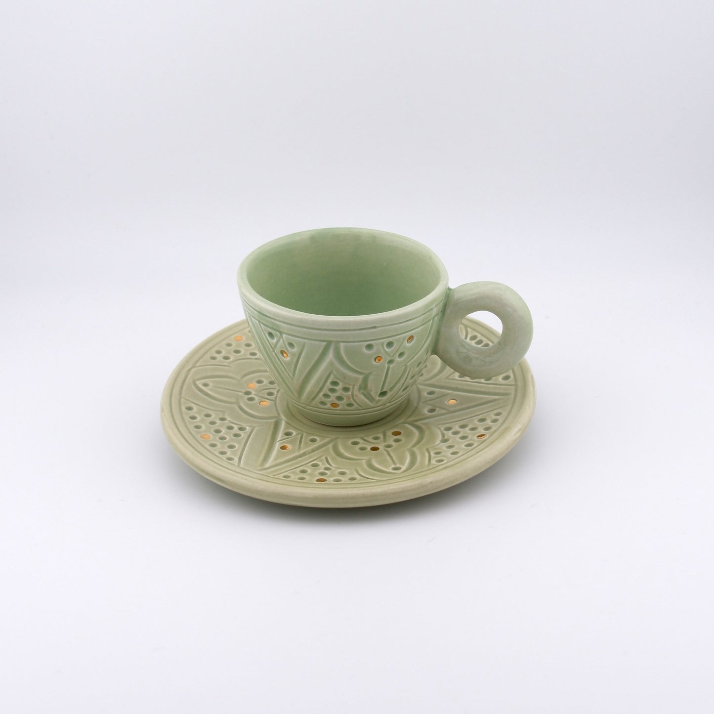 Product image of a handmade, Moroccan espresso cup with handle and matching saucer and in Green color. Decorated with gold elements as well as traditional engravings. 